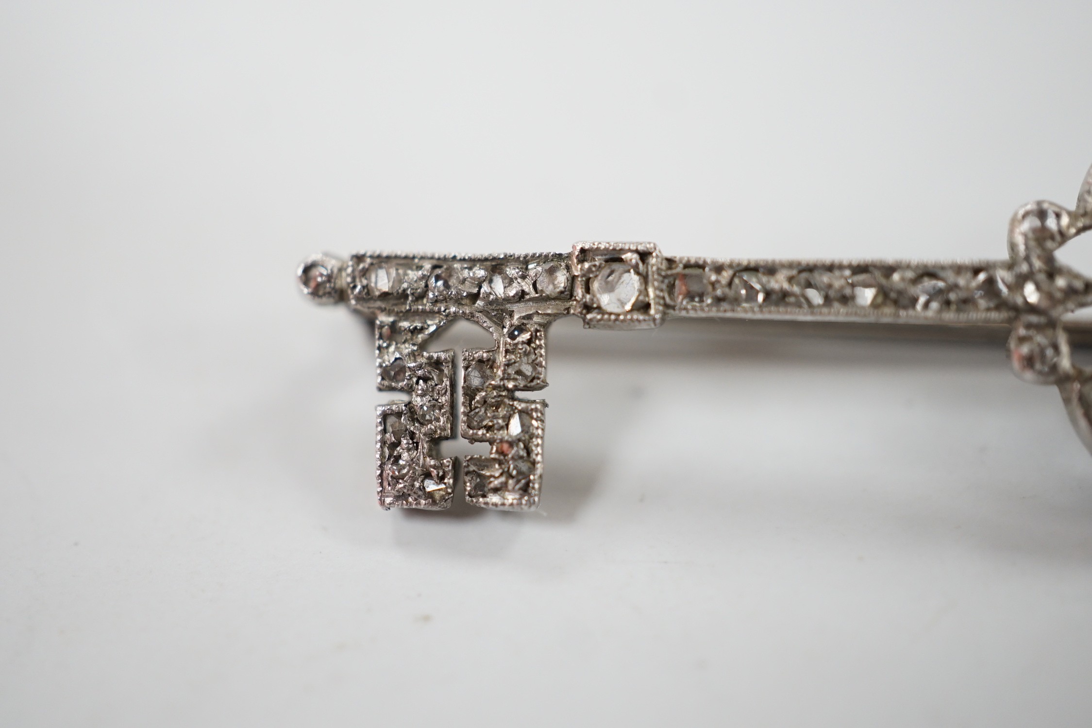 An early 20th century white metal and rose cut diamond set 'key of the door' brooch, 33mm, gross weight 2.1 grams.